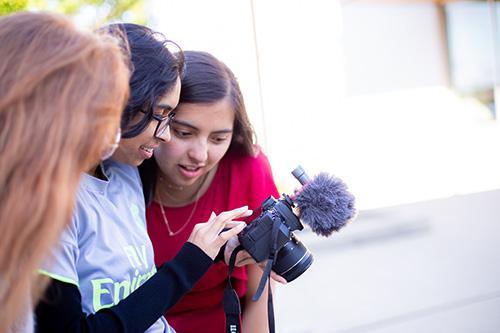 Three young women looking at a camera screen together